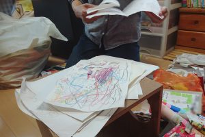 子どもの作品に一つ一つ目を通して整理するお母さん